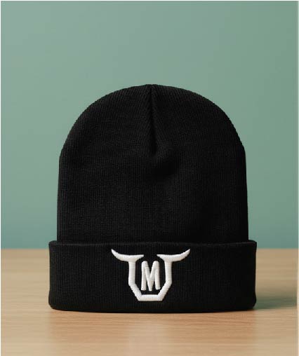 Black folded beanie with white embroidered bull horns surrounding a letter M.
