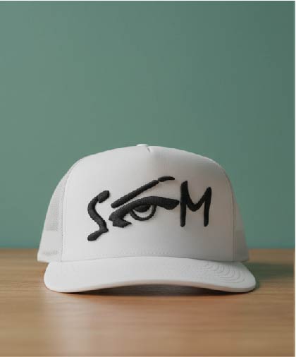 White foam trucker hat with a black abstract embroidered eye and 'SGM' text.