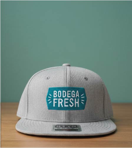 Grey flat bill snapback cap with a teal and white embroidered 'BODEGA FRESH' patch.